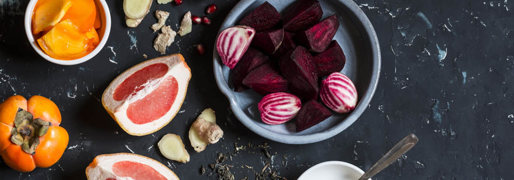 Ingredients for cooking beet and ginger detox elixir. On a dark background, top view